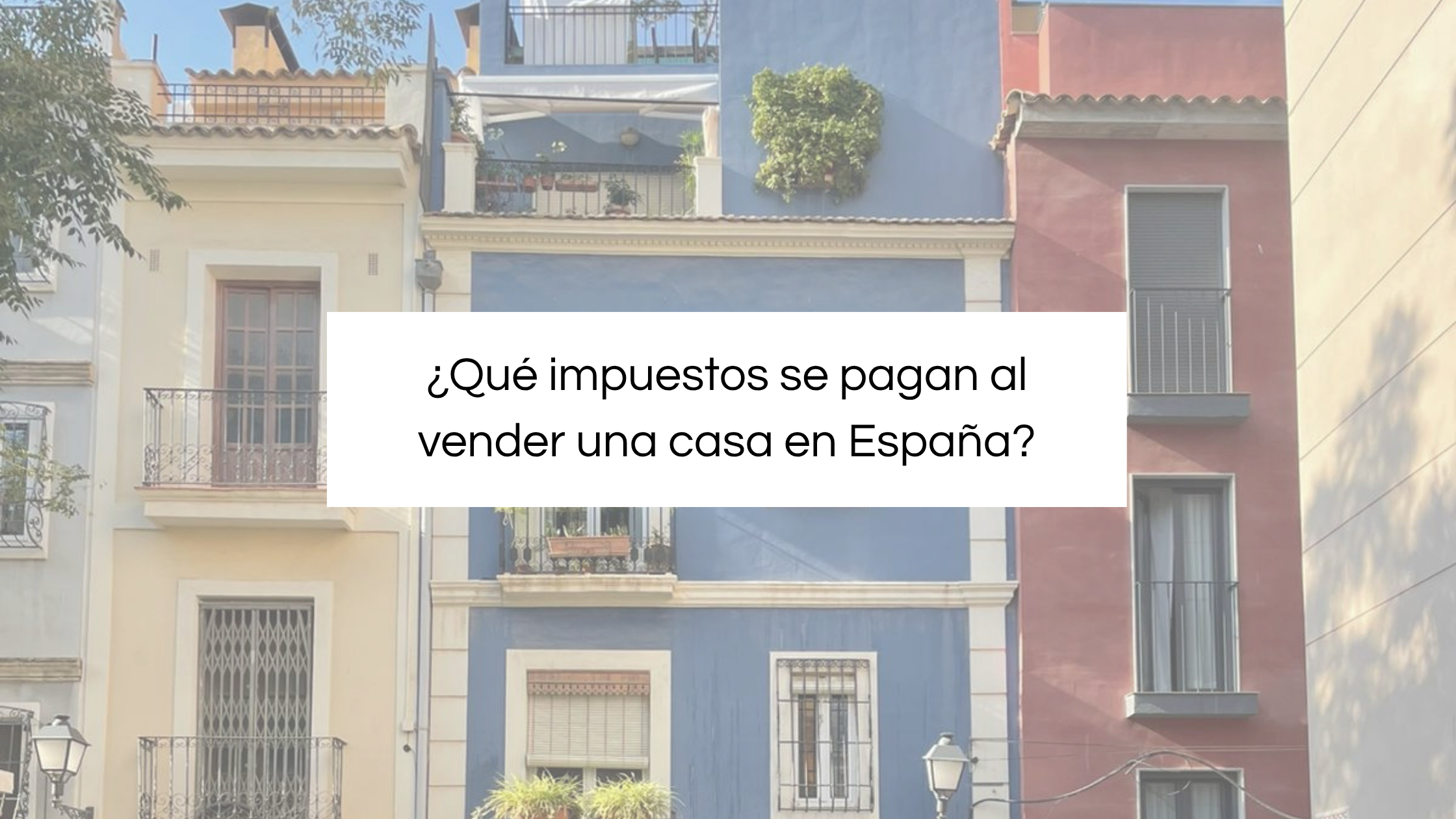 Fachadas de casas coloridas en una calle de España con información sobre qué impuestos se pagan al vender una casa